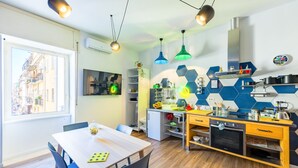 Una cocina moderna con comedor, que incluye una mesa de madera, sillas y un horno empotrado.