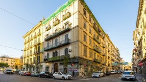 Un edificio de varios pisos con balcones y una calle en primer plano.