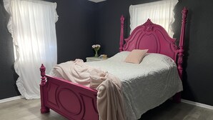 A bed with a pink headboard and footboard, a white bedspread, and a beige blanket. - Sunsets in Brookston (Brookston)