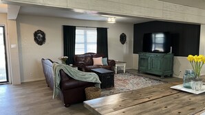 A living room with a brown leather sofa, a wooden coffee table, and a green cabinet. - Sunsets in Brookston (Brookston)