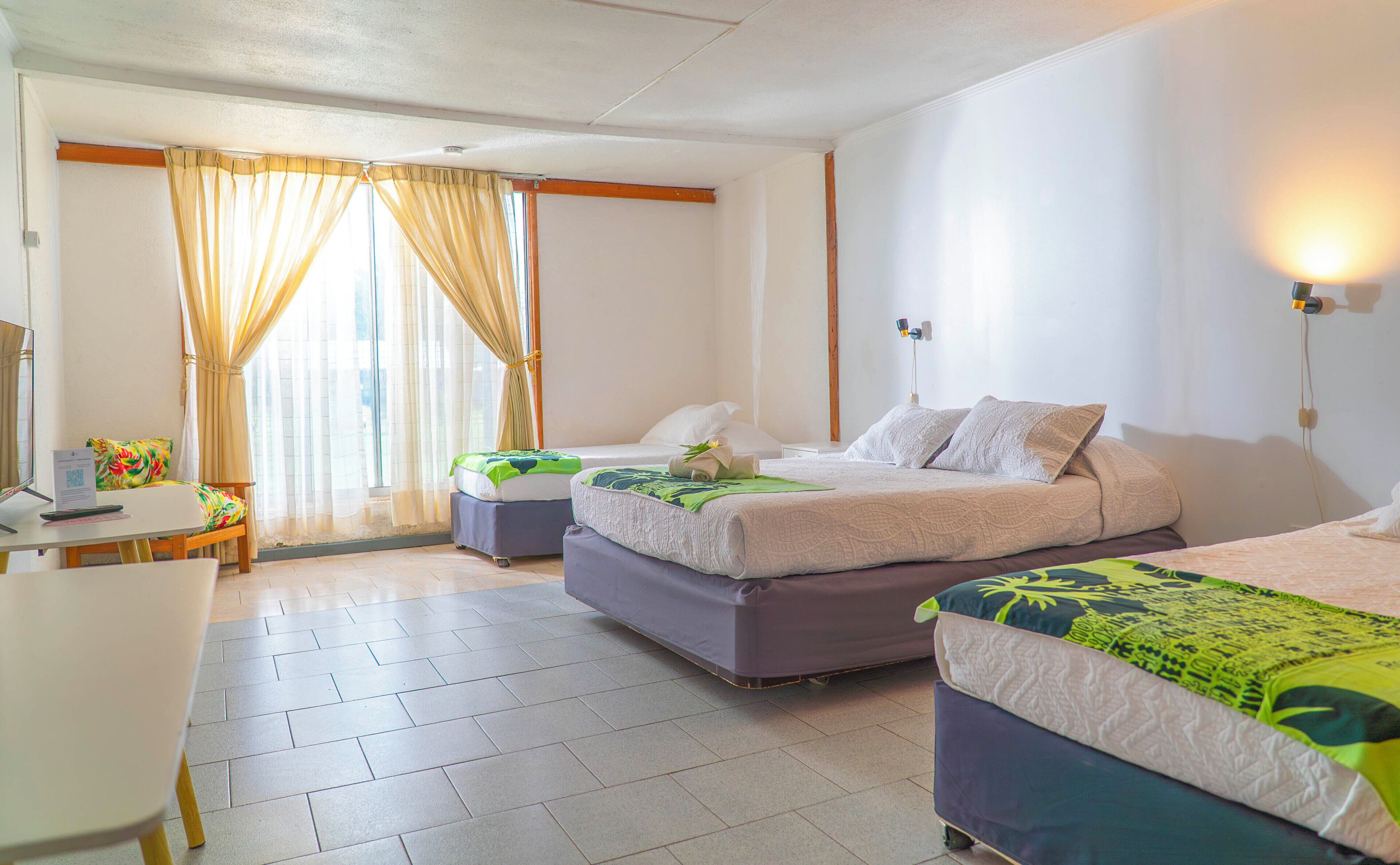 Una habitación de hotel con una cama, un escritorio y una silla.
