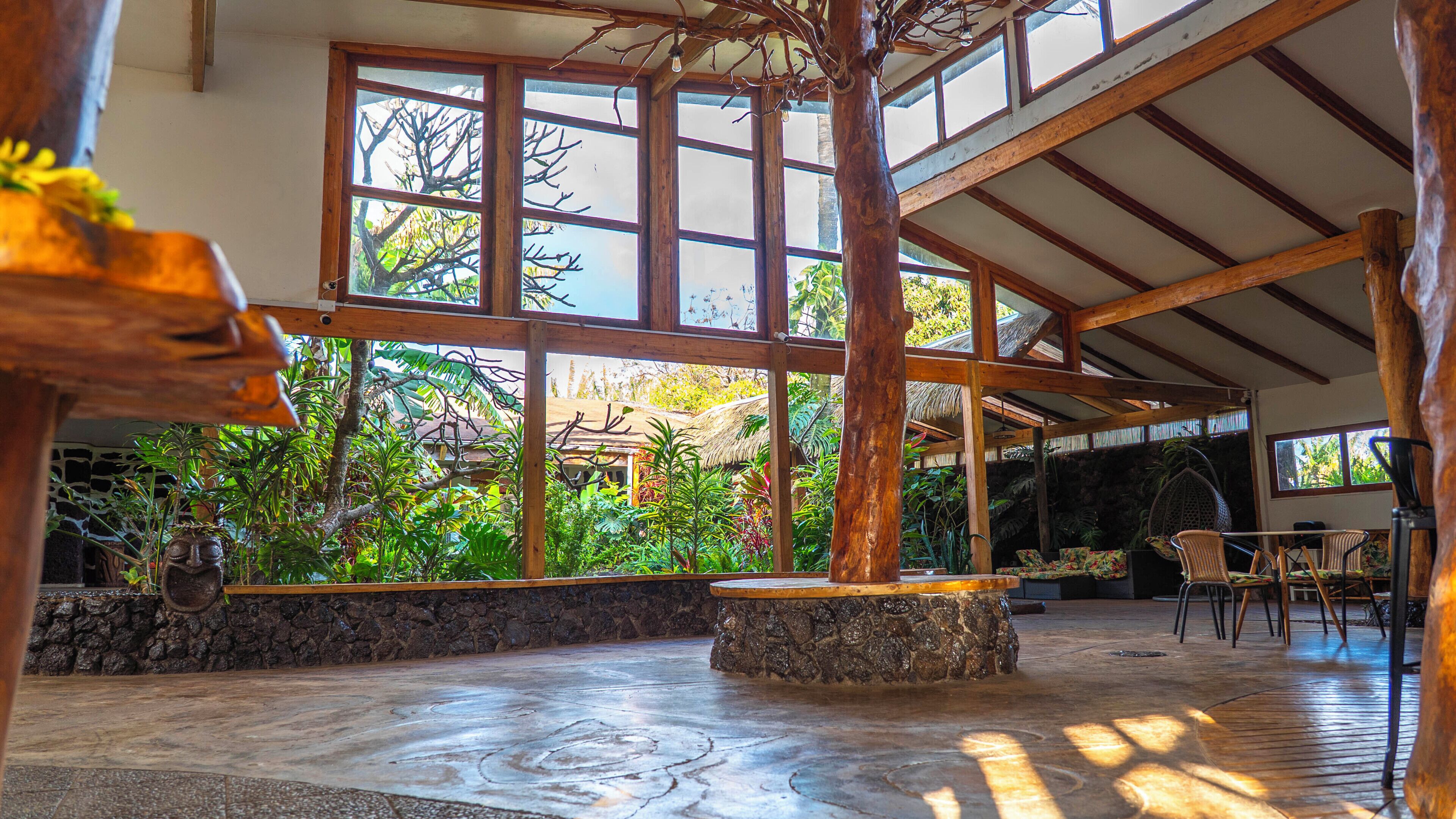 A spacious indoor area with large windows, stone walls, and wooden beams.
