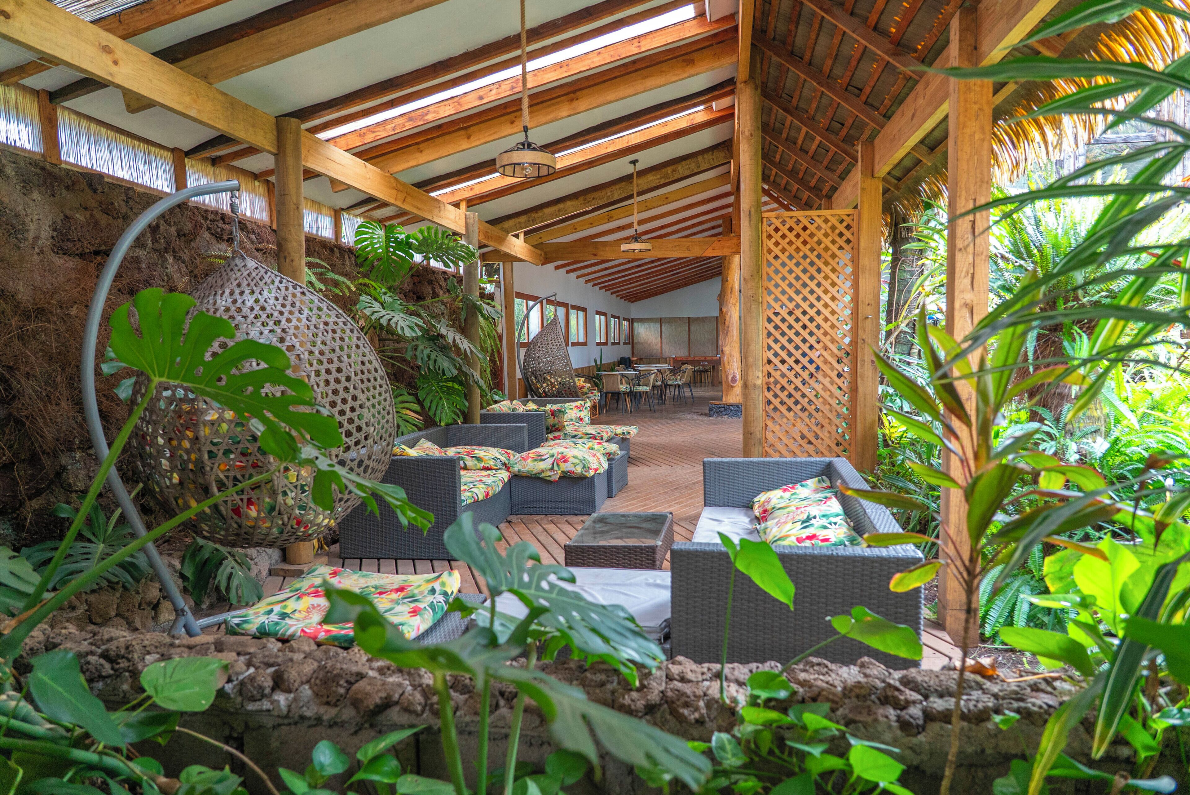 An outdoor seating area with wicker furniture and tropical plants.