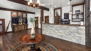 Un intérieur rustique avec un comptoir en pierre, des poutres en bois et une carte des cafés.