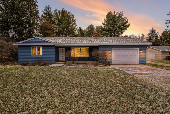 A single-story house with a garage, a front porch, and a chimney.