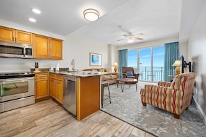 A modern kitchen with wooden cabinets, stainless steel appliances, and a central island. - Beachfront Luxury Villa, Ocean Walk Resort, Daytona Beach (Daytona Beach)