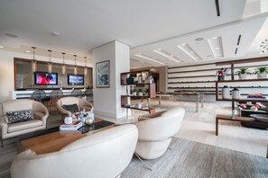 A modern living room with a sofa, armchairs, a coffee table, and a TV. There is a kitchen area with a dining table and chairs. The room has a contemporary design with a neutral color palette. - 2 Bedroom at Southwest Waterfront (Washington)