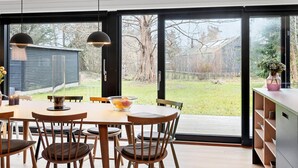 A modern dining area with a large table, chairs, and pendant lights. - Awesome home in Stege with kitchen (Stege)