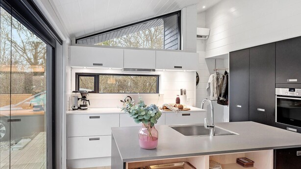 A modern kitchen with a large island, a built-in oven, and a window overlooking a deck. - Awesome home in Stege with kitchen (Stege)