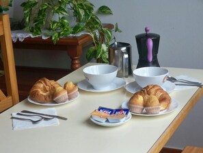 A breakfast setup with croissants, coffee, and tea on a table. - Alto Santiago (San Vicente de la Barquera)