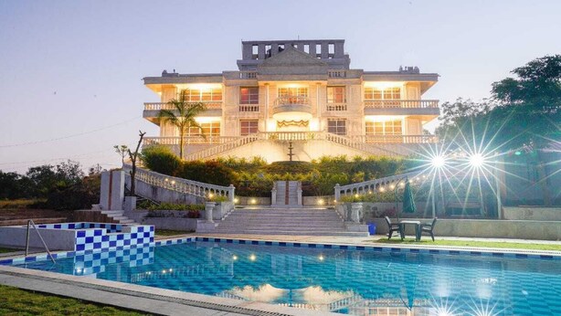 Un edificio grande de varios pisos con una piscina delantera.