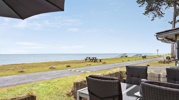 A patio area with outdoor seating and a view of the beach.