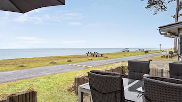 Un espace patio avec des sièges extérieurs et une vue sur la plage.