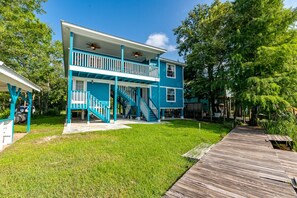 A two-story house with a wooden deck and a covered porch. - Waterfront W/ Private Dock • Fishing • Pet Friendly (Gulfport)