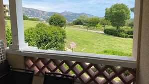 A balcony with a view of a green landscape, trees, and distant mountains. - Cap Esterel Saint Raphael T2 vue mer + Parking (Saint-Raphaël)