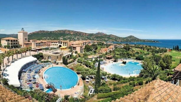 A resort with multiple swimming pools, a central courtyard, and a mountainous backdrop. - Cap Esterel Saint Raphael T2 vue mer + Parking (Saint-Raphaël)