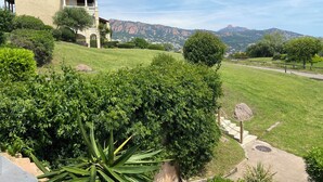 A residential area with a house, lush greenery, and a mountainous backdrop. - Cap Esterel Saint Raphael T2 vue mer + Parking (Saint-Raphaël)