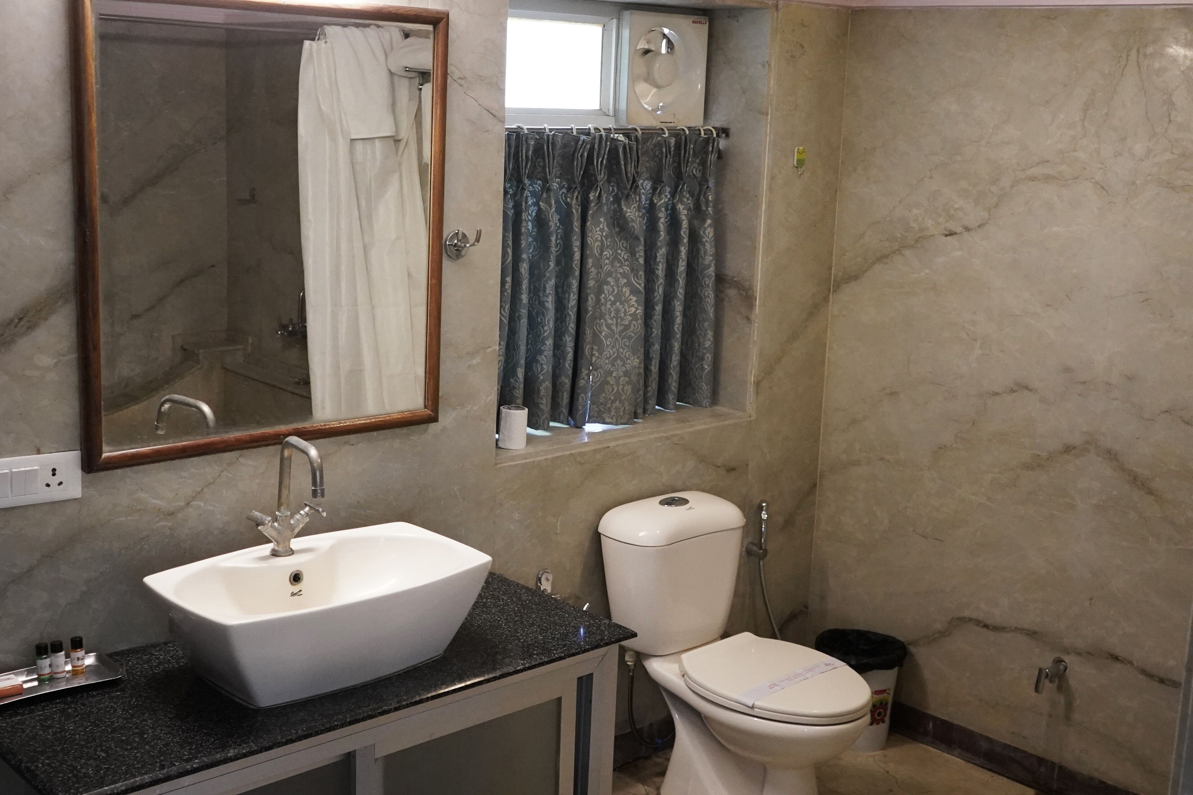 Casa de banho com lavatório branco, sanita e zona de duche.