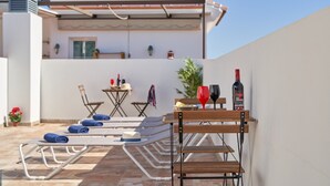 A rooftop terrace with lounge chairs, a table with drinks, and a bar area. - Studio Apartment "Nerja Boutique Street Level B1" with Shared Pool & Wi-Fi (Nerja)