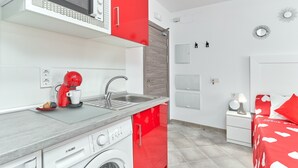 A modern kitchen with a microwave, coffee maker, and washing machine. - Studio Apartment "Nerja Boutique Street Level B1" with Shared Pool & Wi-Fi (Nerja)