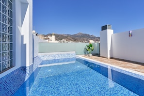 A rooftop pool with blue mosaic tiles, a potted plant, and a view of mountains in the background. - Studio Apartment "Nerja Boutique Deluxe 103" with Shared Pool & Wi-Fi (Nerja)
