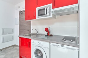 A compact kitchen with a washing machine, a microwave, and a coffee machine. - Studio Apartment "Nerja Boutique Deluxe 103" with Shared Pool & Wi-Fi (Nerja)