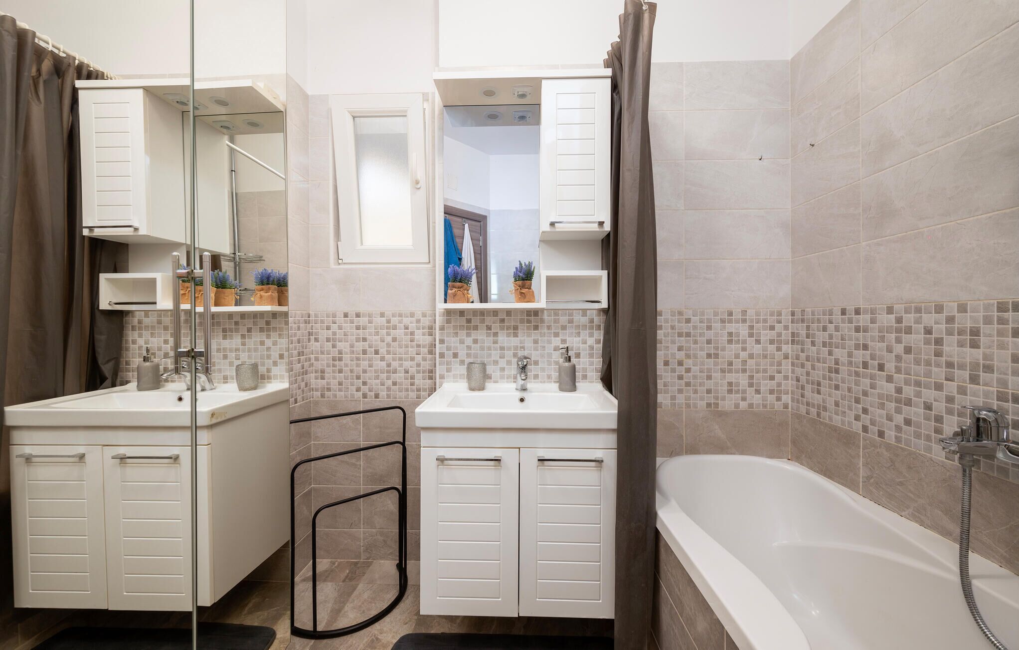 A modern bathroom with two sinks, a shower, and a glass-enclosed shower area.