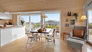 Una cocina amplia con comedor, ventanas grandes y una zona de estar acogedora con vistas.