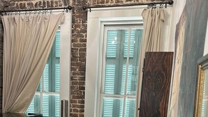 A cozy room with a brick wall, a wooden table, a cushioned bench, and a trash bin. - Heart of Downtown w Balcony by Dauphin St; walk to restaurants & shops SLEEPS 6! (Mobile)