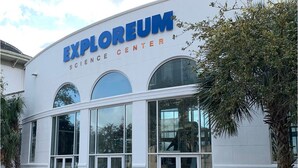 The exterior of the Explorium Science Center with large glass windows and a white facade. - Heart of Downtown w Balcony by Dauphin St; walk to restaurants & shops SLEEPS 6! (Mobile)