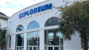 The exterior of the Explorium Science Center with large glass windows and a white facade. - Heart of Downtown w Balcony by Dauphin St; walk to restaurants & shops SLEEPS 6! (Mobile)