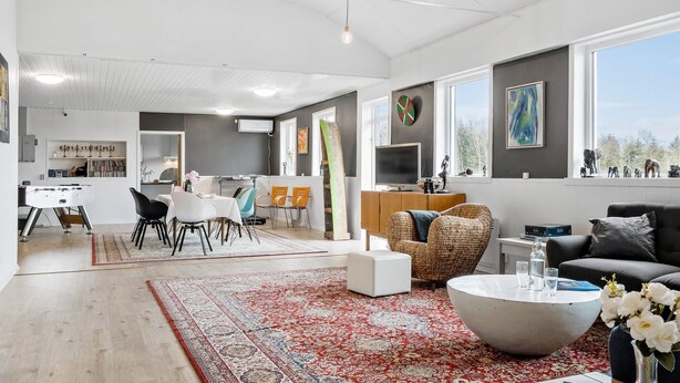 A spacious living area with a large rug, a coffee table, and seating. There is a kitchen area in the background with a dining table and chairs. - Amazing home in Vandel with Wi-Fi (Vandel)