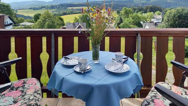 A table set for two with a view of a rural landscape. - Stunning apartment in Winterberg (Winterberg)