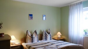 A bedroom with a bed, two bedside tables, a lamp, a window with curtains, and two wall-mounted pictures. - Stunning apartment in Winterberg (Winterberg)
