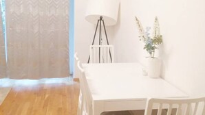 A room with a white table, a white chair, a floor lamp, and a potted plant. - Gemütliche Wohnung in Leipzig Zentrum mit Terrasse (Leipzig)
