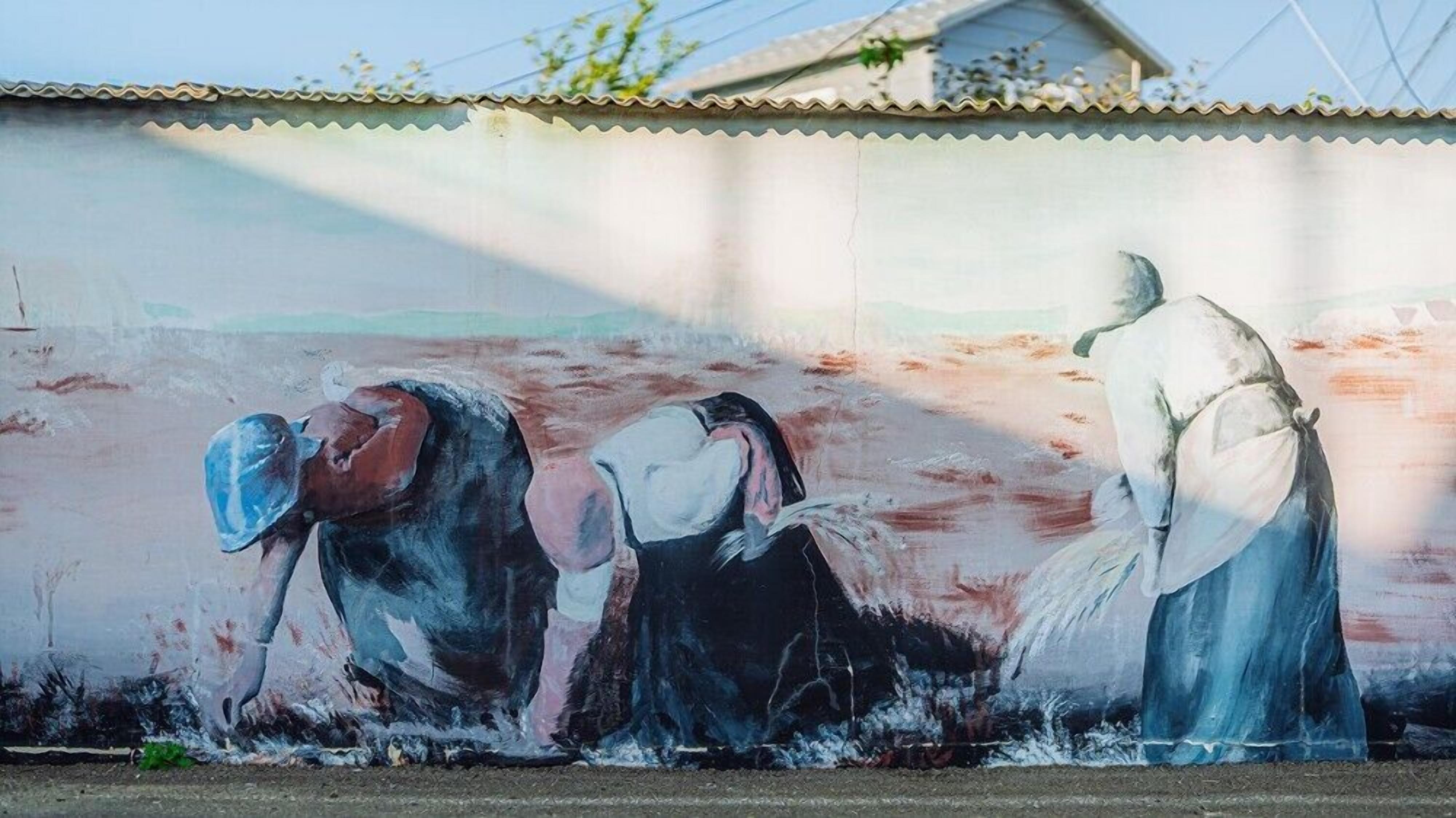 A mural of three figures on a wall.