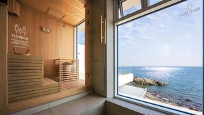 Quarto com painéis de madeira, janela com vista para o mar e placa indicando uma área de cuidados para crianças.