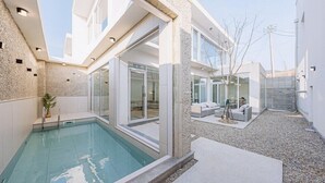 A modern house with a swimming pool, large glass doors, and a stone exterior. - Stay 13 Wol (Gyeongju)