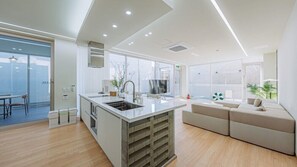 A modern kitchen with a central island, built-in appliances, and large windows. - Stay 13 Wol (Gyeongju)