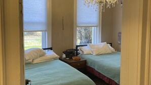 A room with two beds, a chandelier, a typewriter, and a sign reading "Capulin". - Springer Station (Springer)