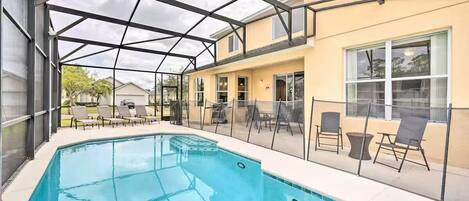 Una piscina interior con techo de cristal, rodeada de sillas y mesas de descanso.