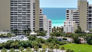 Um hotel moderno com vários andares, estacionamento e vista para o oceano.