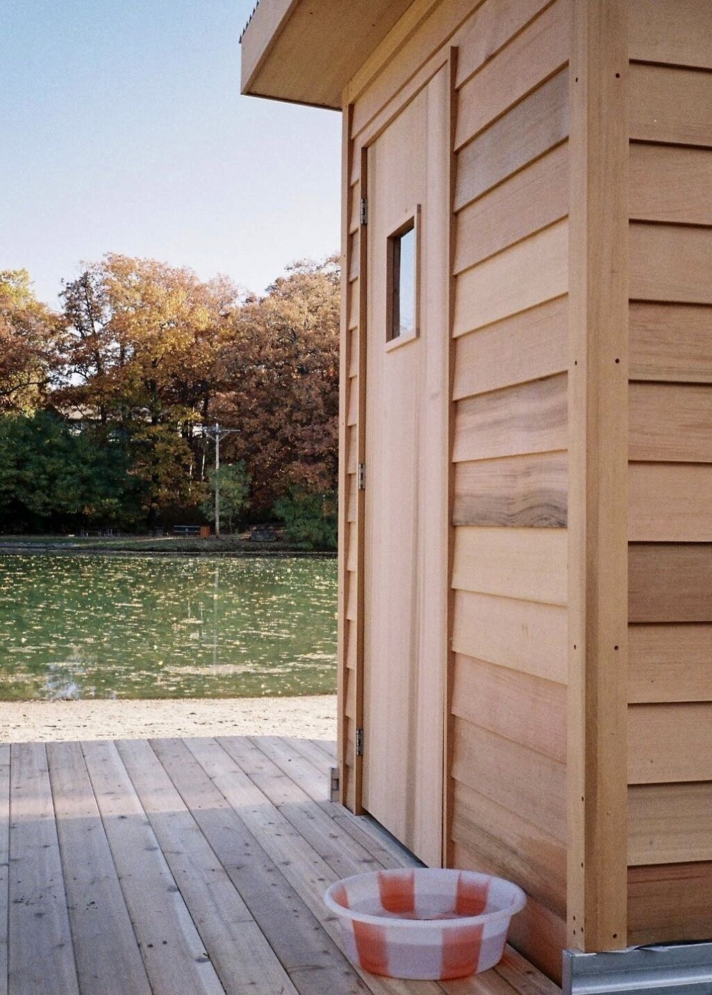 A wooden building with a deck and a small dog bowl.