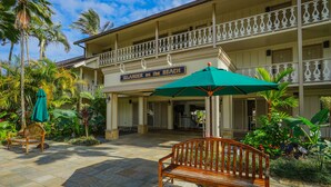 A hotel with a balcony, a wooden bench, and a sign that reads "Islander on the Beach". - Updated Islander Studio | Ground Floor Convenience (Kapaa)