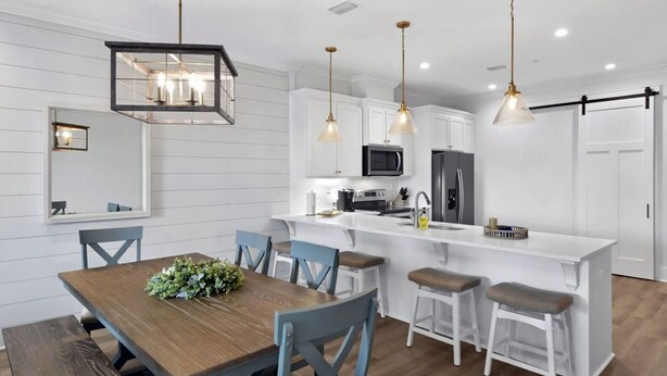 A modern kitchen with white cabinetry, a central island, and pendant lighting.