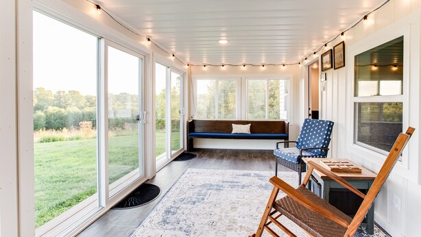 A cozy room with large windows, a bench, a chair, and a small table. - Make the Family Memories Here | Fishing Pond | Indoor Playground | Scenic Views (Nashville)