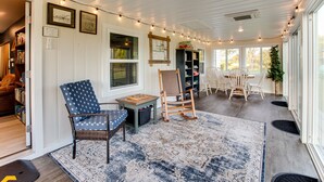 A cozy reading nook with a wicker chair, a small table, and a bookshelf. - Make the Family Memories Here | Fishing Pond | Indoor Playground | Scenic Views (Nashville)