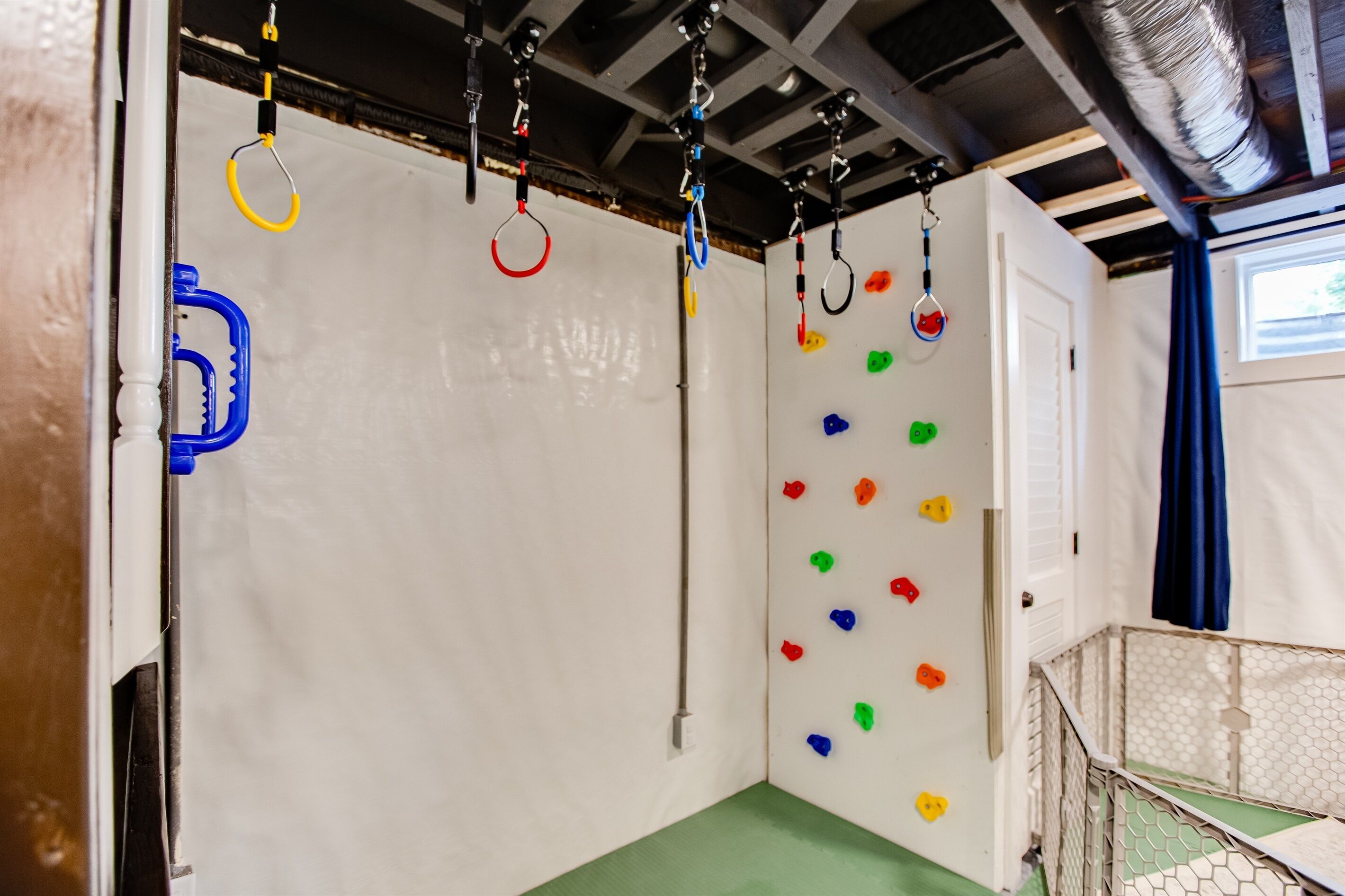 Eine Kletterwand mit bunten Griffen und einer Metall-Kletterkonstruktion.