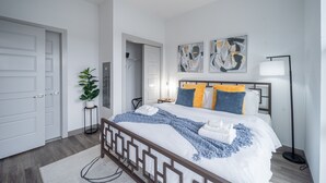A modern bedroom with a bed, a potted plant, and artwork on the wall. - 2 King Bed 2 Bath Easy ride to NYC and Shopping (Hackensack)