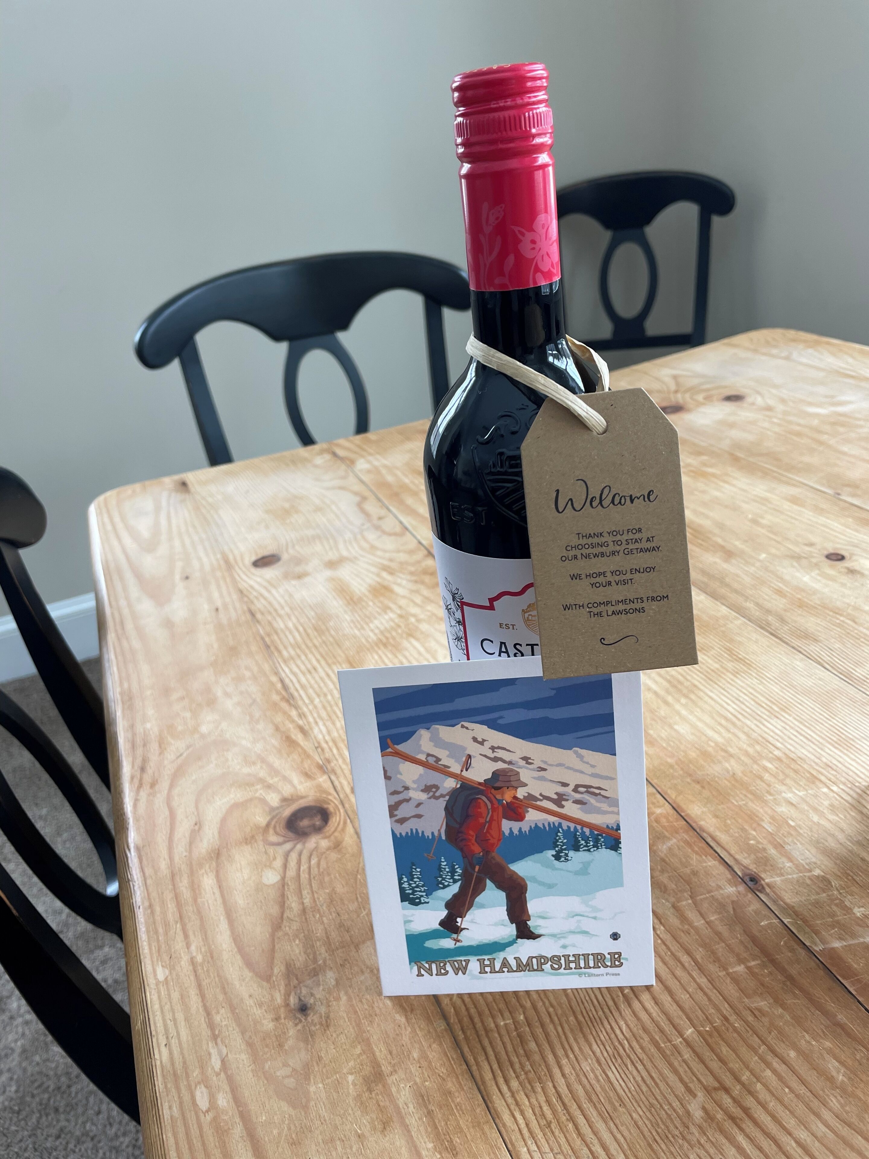 Una bottiglia di vino con tappo rosso e un’etichetta su un tavolo di legno.